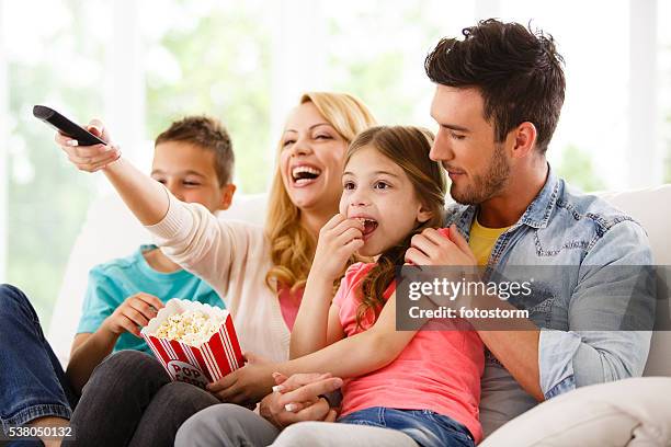 family watching television in living room - home cinema stockfoto's en -beelden