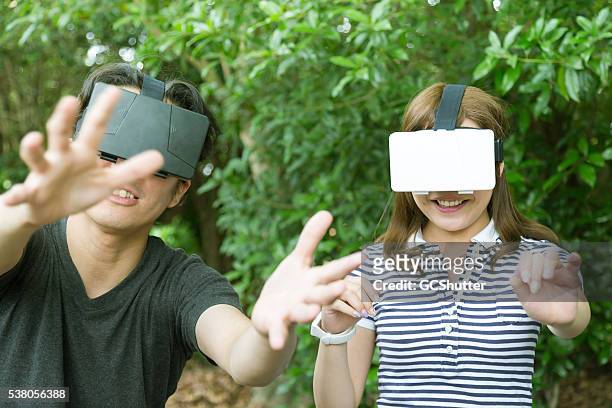 freunde spaß haben mit virtuelle reality-konsolen - head mounted display stock-fotos und bilder