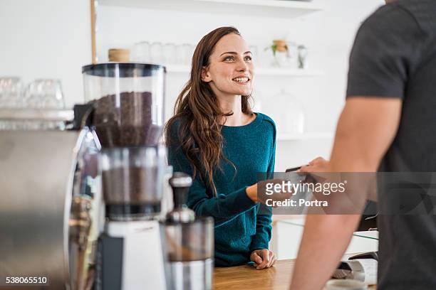cashier receiving payment from customer in cafe - debit cards credit cards accepted stock pictures, royalty-free photos & images