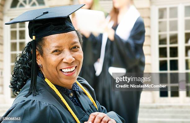 mature african american woman on graduation day - mature student stockfoto's en -beelden