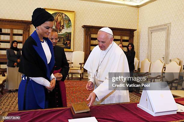 Pope Francis exchanges gifts with Sheikha Mozah bint Nasser Al Missned at his private library in the Apostolic Palace on June 4, 2016 in Vatican...