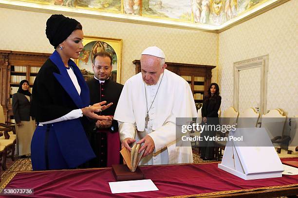 Pope Francis exchanges gifts with Sheikha Mozah bint Nasser Al Missned at his private library in the Apostolic Palace on June 4, 2016 in Vatican...