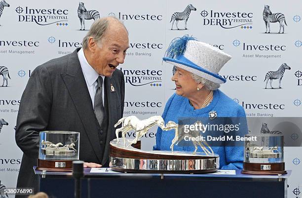 His Highness The Aga Khan receives the Investec Derby trophy for his winning horse Harzand from HRH Queen Elizbaeth II during Derby Day at the...