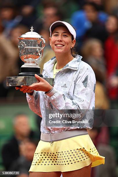 Garbine Muguruza of Spain poses with the trophy following her victory during the Ladies Singles final match against Serena Williams of the United...