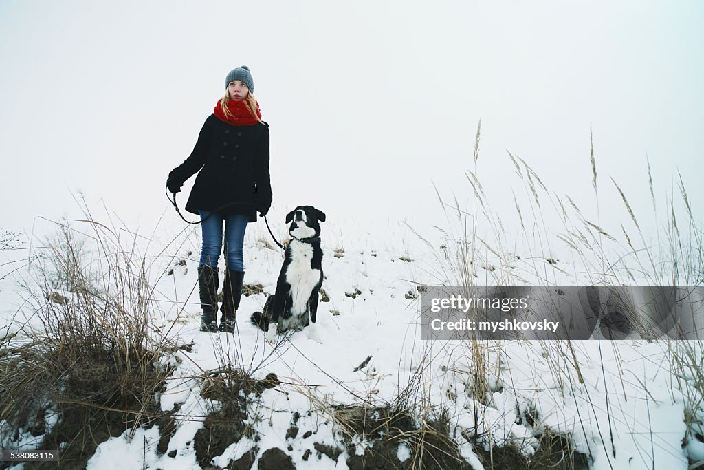 Woman playing with the dog in fresh snow