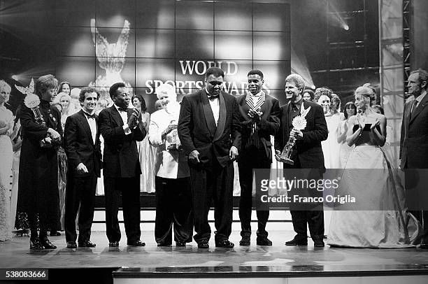 Annemarie Moser-Proell, Alain Prost, Pele, Dawn Fraser, Carl Lewis, Mark Spitz, Nadia Comaneci and Jean-Claude Killy applause Muhammad Ali as he...