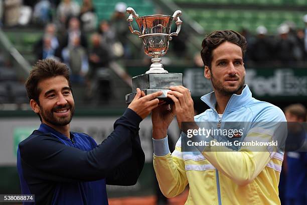 Marc Lopez and Feliciano Lopez of Spain celebrate with the trophy following their victory during the Men's Doubles final match against Mike Bryan and...