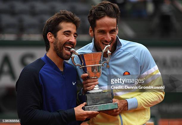 Marc Lopez and Feliciano Lopez of Spain celebrate with the trophy following their victory during the Men's Doubles final match against Mike Bryan and...