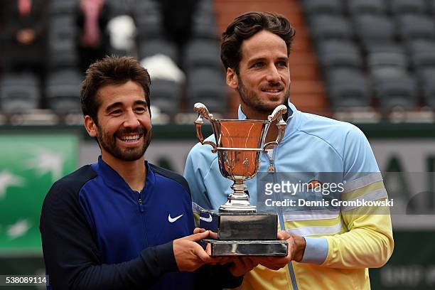 Marc Lopez and Feliciano Lopez of Spain celebrate with the trophy following their victory during the Men's Doubles final match against Mike Bryan and...