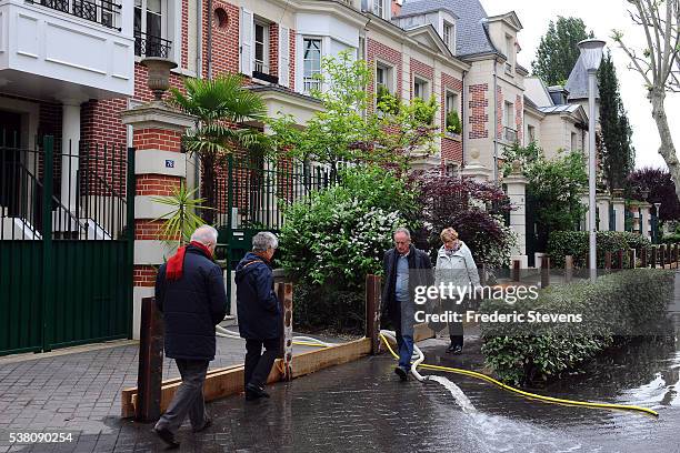 Floods the Ile de la Jatte in Neuilly-sur-Seine near Paris some houses use sump pumps, and emit streams of water on the pavement under the feet of...