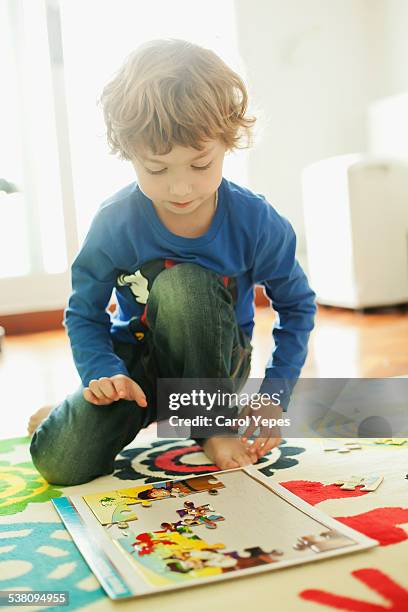 portrait of a child playing jigsaw puzzle - teppich unfertig stock-fotos und bilder