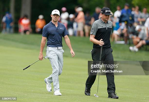 Rory McIlroy of Northern Ireland and Keegan Bradley walk down the fairway on the first hole during the third round of The Memorial Tournament at...