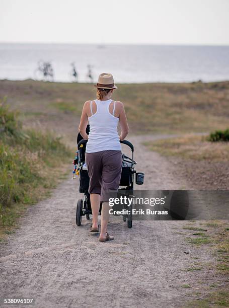 mother with hat pushing baby trolley - varberg stock pictures, royalty-free photos & images