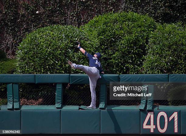 Kirk Nieuwenhuis of the Milwaukee Brewers climbs the wall and watches as the ball hit by Tommy Joseph of the Philadelphia Phillies goes over the...