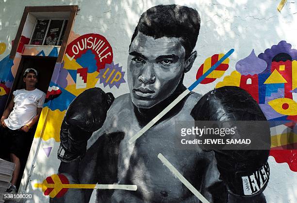 Man stands next to a mural of boxer Muhammad Ali in New York on June 4, 2016. Ali, the three-time world heavyweight champion and colorful civil...
