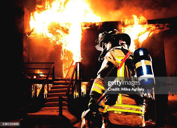 fireman preparing to enter burning building - mike agliolo stockfoto's en -beelden