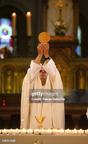 priest holding host in saint ambroise church - saint ambroise stock pictures, royalty-free photos & images