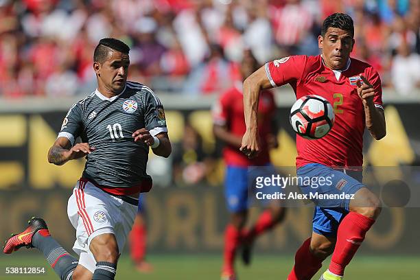 Derlis Gonzalez of Paraguay and Johnny Acosta of Costa Rica chase a loose ball during the 2016 Copa America Centenario Group A match between Costa...