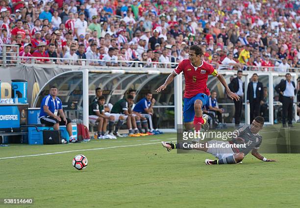 Celso Borges of Costa Rica is tackled by Derlis Gonzalez of Paraguay at the group A match between Costa Rica and Paraguay at Camping World Stadium as...