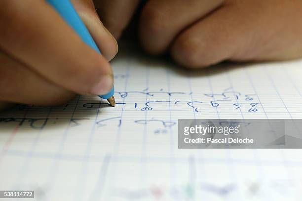 child learning to write in arabic - escritura árabe fotografías e imágenes de stock
