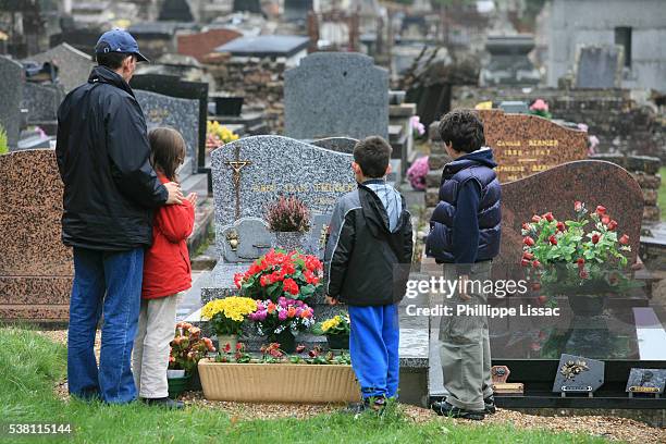 family visiting a graveyard - viudo fotografías e imágenes de stock