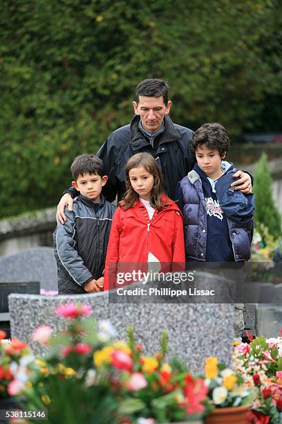 family visiting a graveyard - mourner stock-fotos und bilder