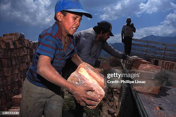 child worker loading bricks onto a truck - child labour stock pictures, royalty-free photos & images
