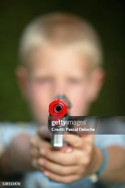 boy pointing toy pistol - arma de brinquedo imagens e fotografias de stock