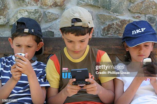 children playing with electronic games - handheld video game stock pictures, royalty-free photos & images