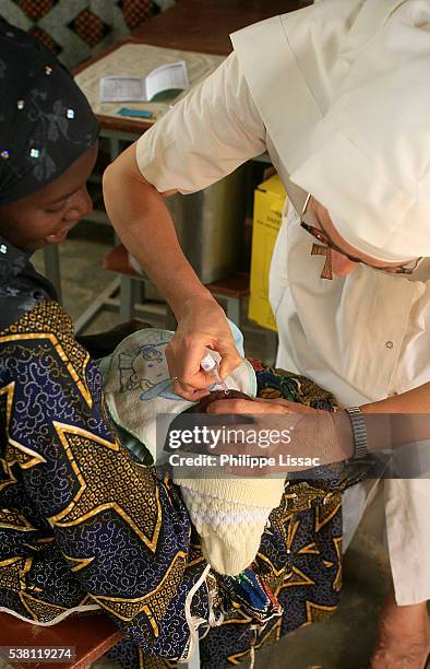 nun giving oral vaccination to infant - nun hospital stock pictures, royalty-free photos & images