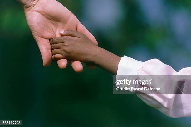 child holding adult's hand - adoption photos et images de collection