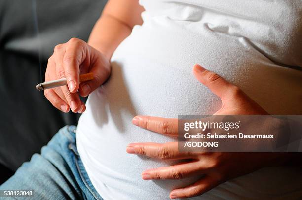 pregnant woman smoking - woman smoking cigarette stock-fotos und bilder