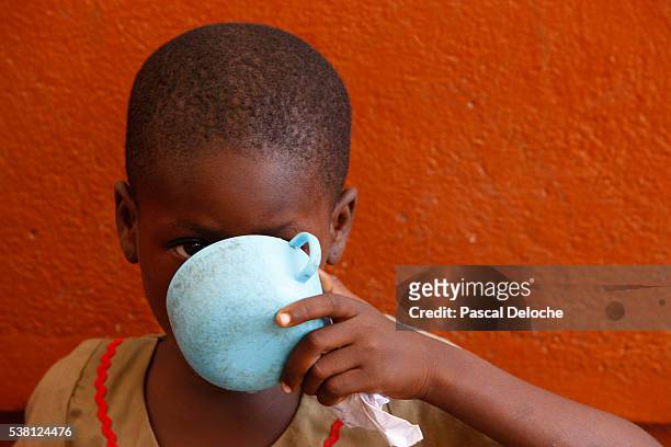 drinking water in africa - african africa child drinking water cup stock pictures, royalty-free photos & images