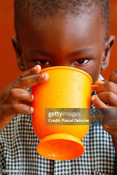 drinking water in africa - african africa child drinking water cup stock pictures, royalty-free photos & images