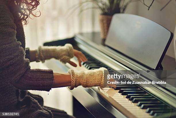 hands of a musician playing the piano with mittens - fingerless gloves 個照片及圖片檔
