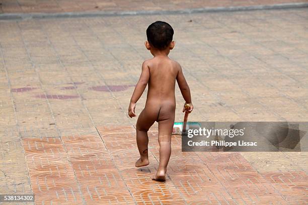 child playing in wat ounalom temple courtyard - wat ounalom stock pictures, royalty-free photos & images