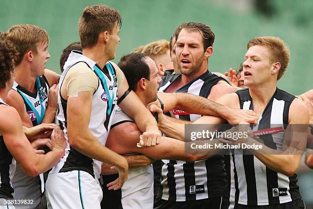 Travis Cloke of the Magpies is caught up in a melee at quarter time with Matthew Broadbent of the Power during the round 11 AFL match between the...