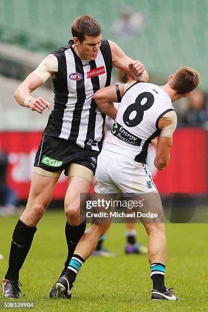 Mason Cox of the Magpies celebrates a goal and bumps Hamish Hartlett of the Power starting a melee during the round 11 AFL match between the...