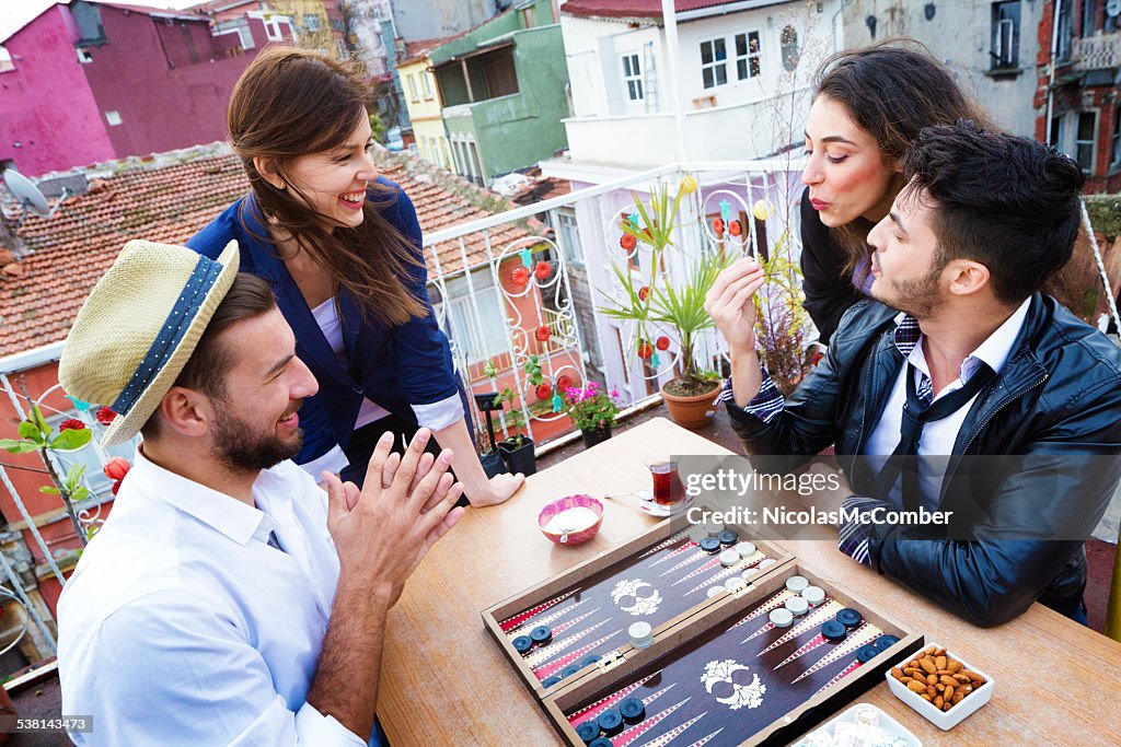 Young woman blows on dice for luck during backgammon game