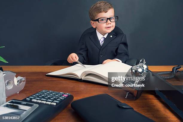 young boy dressed in suit working at desk. - interview funny stock pictures, royalty-free photos & images