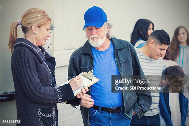 homeless people and families in need signing up for assistance - homeless family stock pictures, royalty-free photos & images