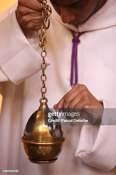 altar server acting as thurifer. preparing the censer. - altar server stock-fotos und bilder