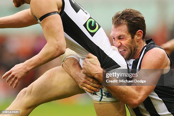 Travis Cloke of the Magpies tackles Aaron Young of the Power during the round 11 AFL match between the Collingwood Magpies and the Port Adelaide...