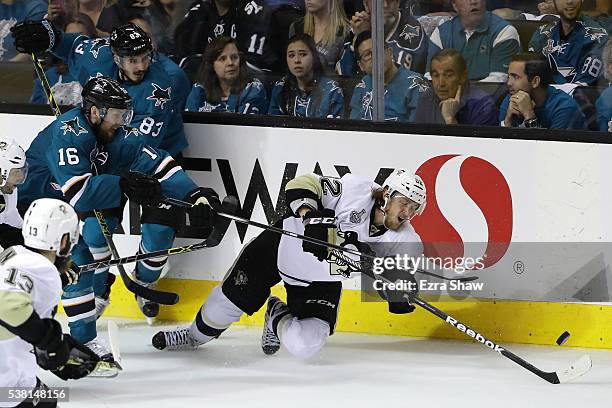 Carl Hagelin of the Pittsburgh Penguins is tripped up by Nick Spaling of the San Jose Sharks in Game Three of the 2016 NHL Stanley Cup Final at SAP...