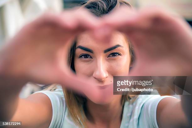 woman making heart shape - making heart shape stock pictures, royalty-free photos & images