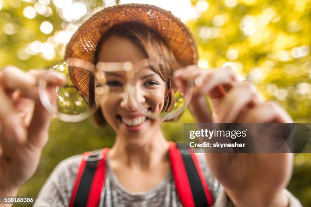 young happy woman seen through eyeglasses lens in nature. - looking through lens stock pictures, royalty-free photos & images