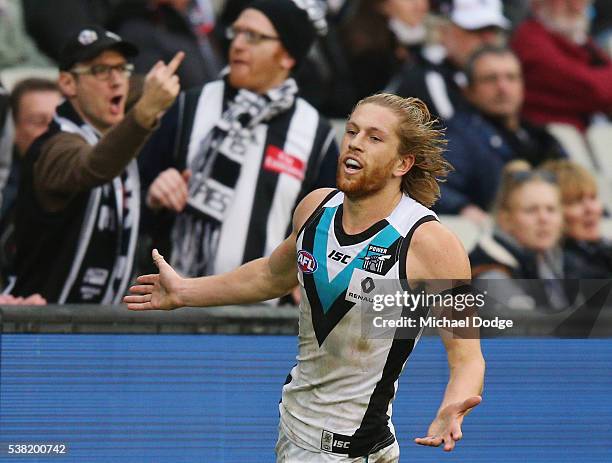 Aaron Young of the Power celebrates a goal as a magpies fan reacts to him during the round 11 AFL match between the Collingwood Magpies and the Port...