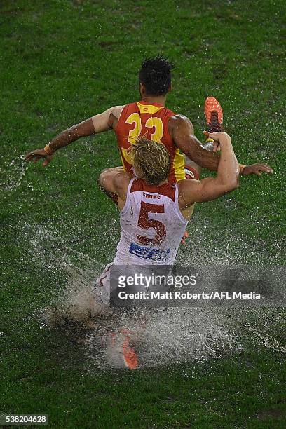 Aaron Hall of the Suns is tackled by Isaac Heeney of the Swans during the round 11 AFL match between the Gold Coast Suns and the Sydney Swans at...