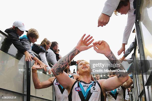 Cameron O'Shea of the Power celebrates the win with fans during the round 11 AFL match between the Collingwood Magpies and the Port Adelaide Power at...