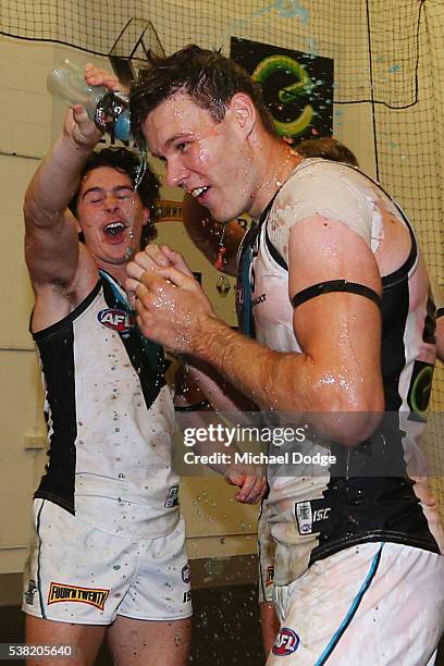 Darcy Byrne-Jones of the Power celebrates the win with Logan Austin during the round 11 AFL match between the Collingwood Magpies and the Port...